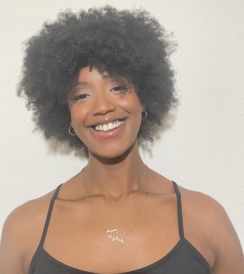 Beautiful Black woman, smiling. her head tilted to the left.